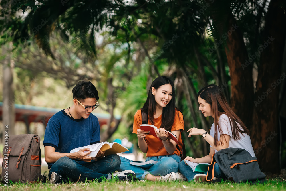 一群年轻或十几岁的亚洲学生在大学里微笑着读着书，看着ta