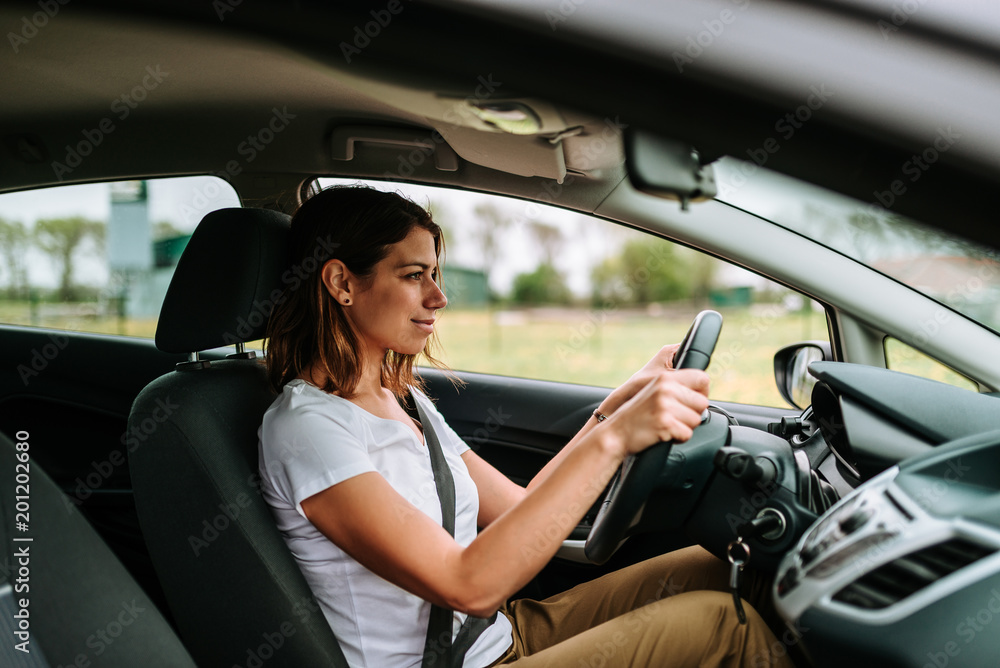 年轻女子在城市里开车。