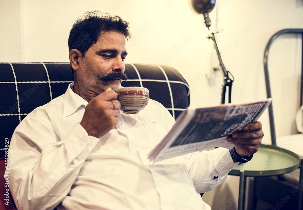 Indian man reading newspaper