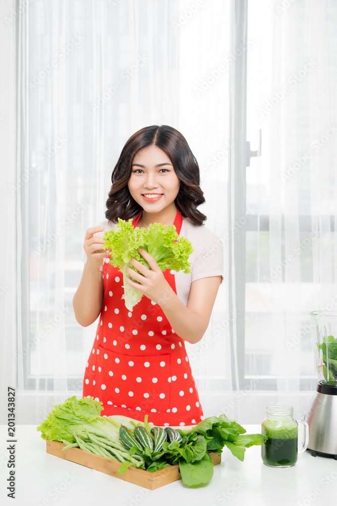 picture of happy woman with lettuce in kitchen