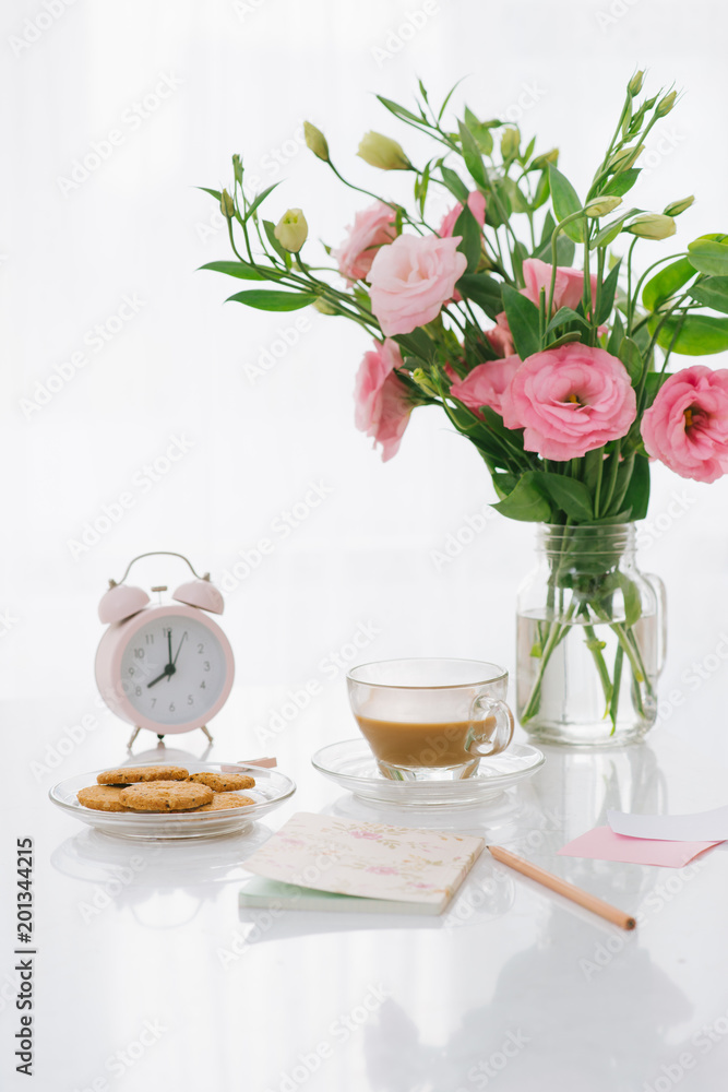 8 am clock. Cookies and flowers on the table.