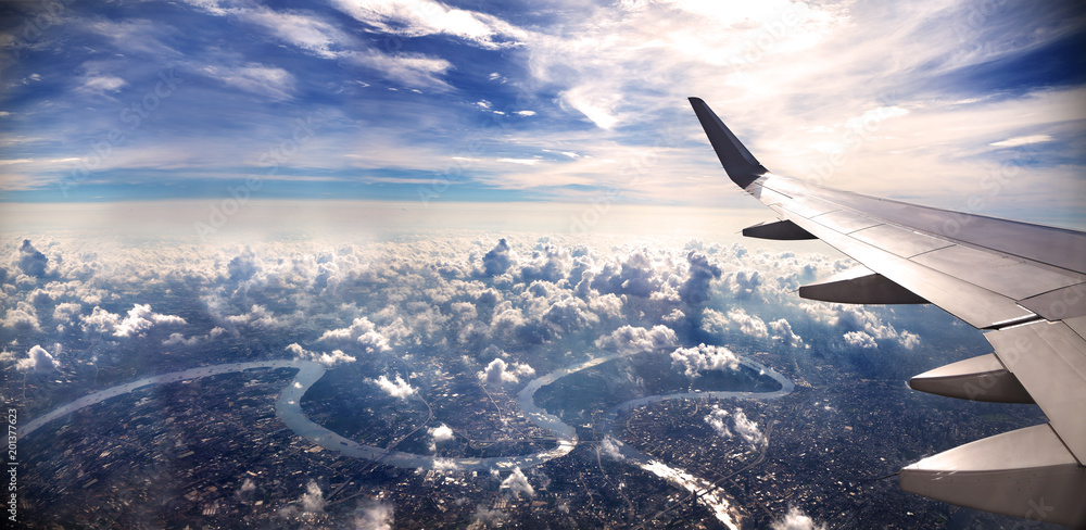 Concepto de viaje en avión .Volando sobre la ciudad hacia el destino. Paisaje al atardecer sobre las