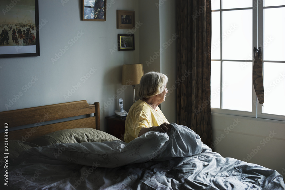 Senior woman sitting in a bedroom