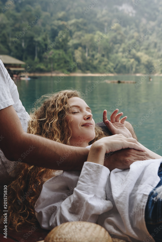 Woman relaxing in her boyfriends lap