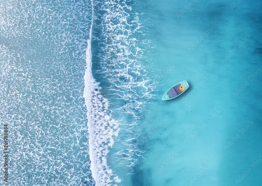 海滩上的波浪和船作为背景。从空中看，夏季的美丽自然背景