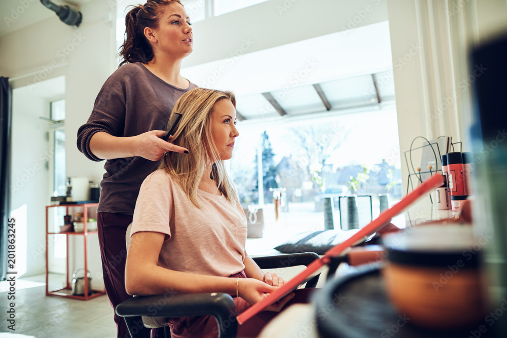 Young woman looking at hair color samples with her hairstylist