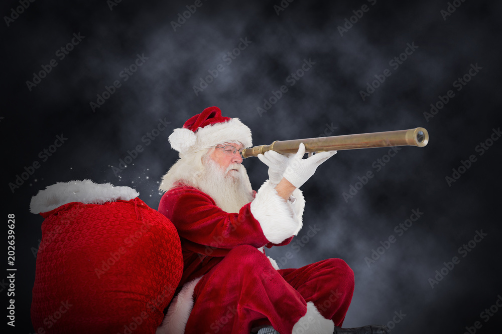 Santa claus looking through telescope against blue background with vignette