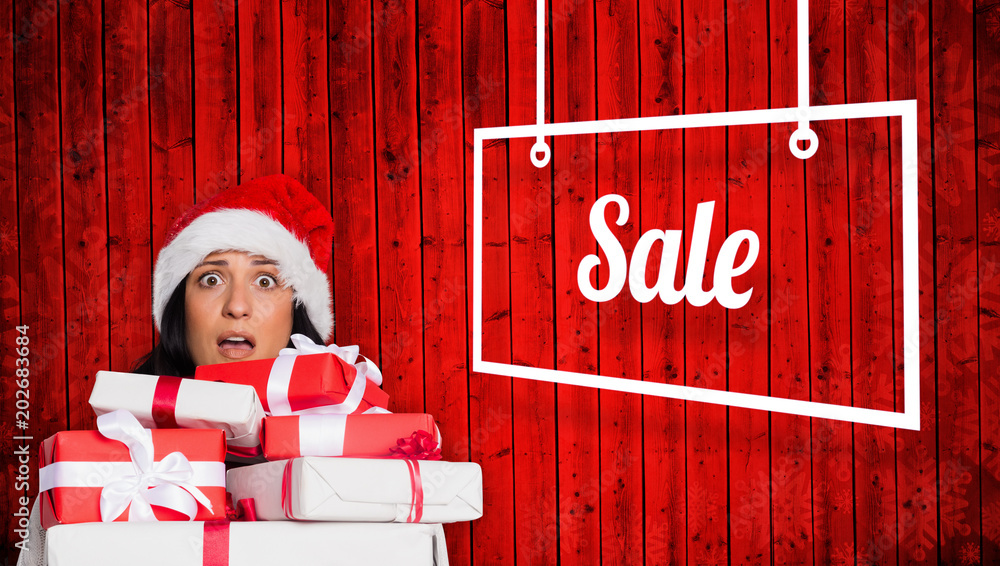 Shocked woman with christmas presents against red wooden planks background