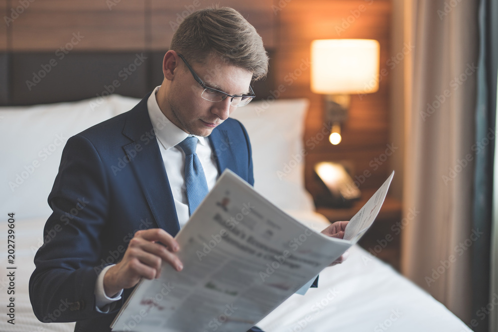 Young businessman reading a newspaper