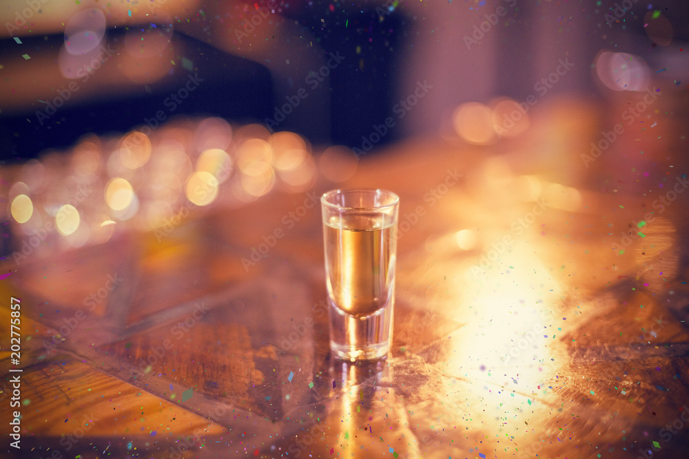 Tequila shot glass on counter against flying colours