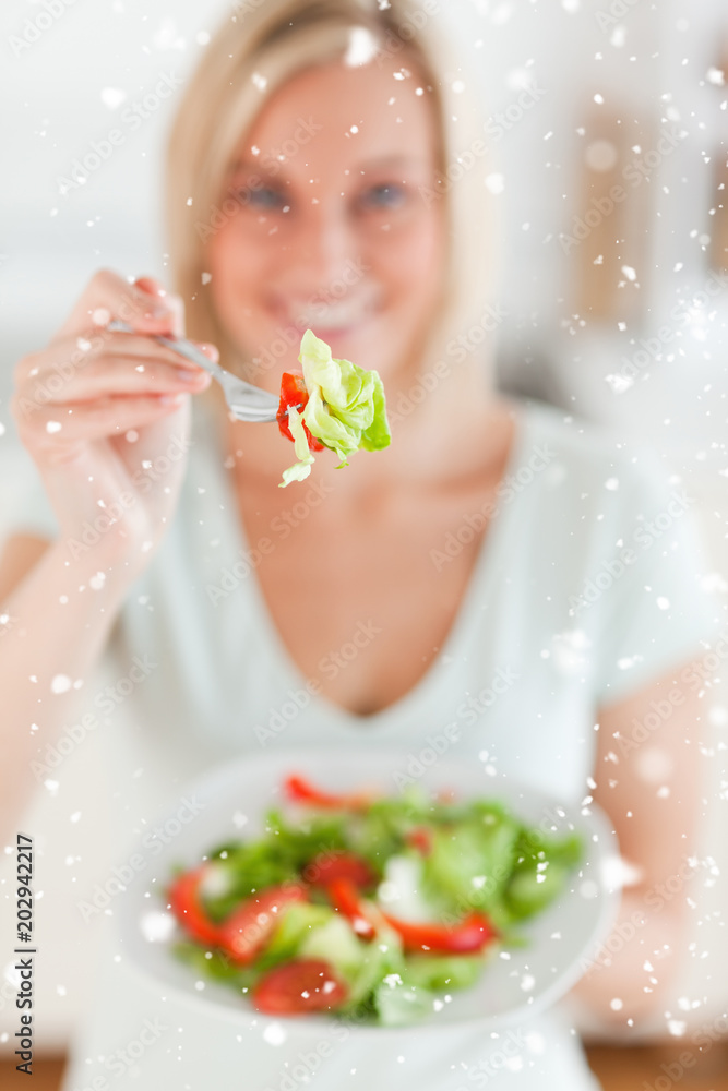 Smiling woman offering salad with snow falling