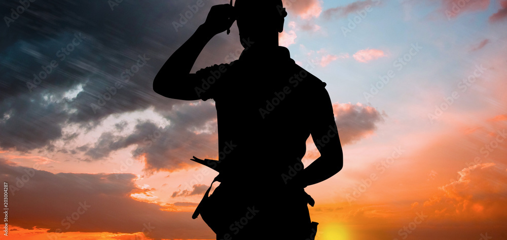 Portrait of smiling manual worker holding clipboard against orange and blue sky with clouds