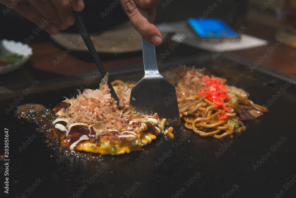 厨师烹饪okonomiyaki；日式煎饼或披萨