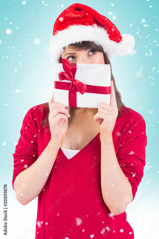 Festive young woman holding a gift against blue vignette