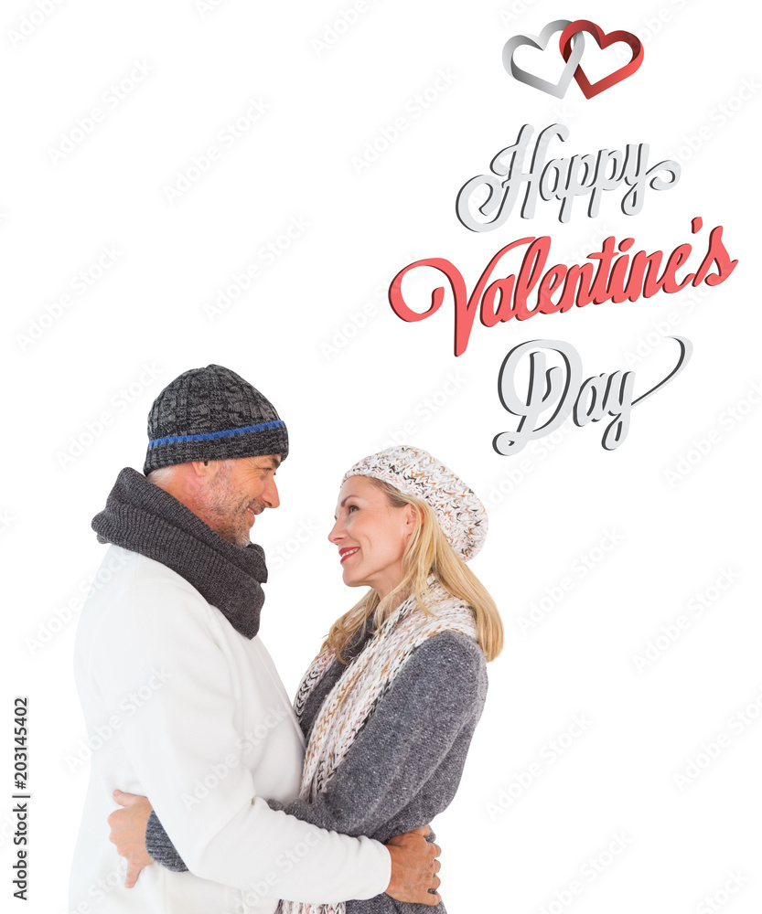 Happy couple in winter fashion embracing against cute valentines message