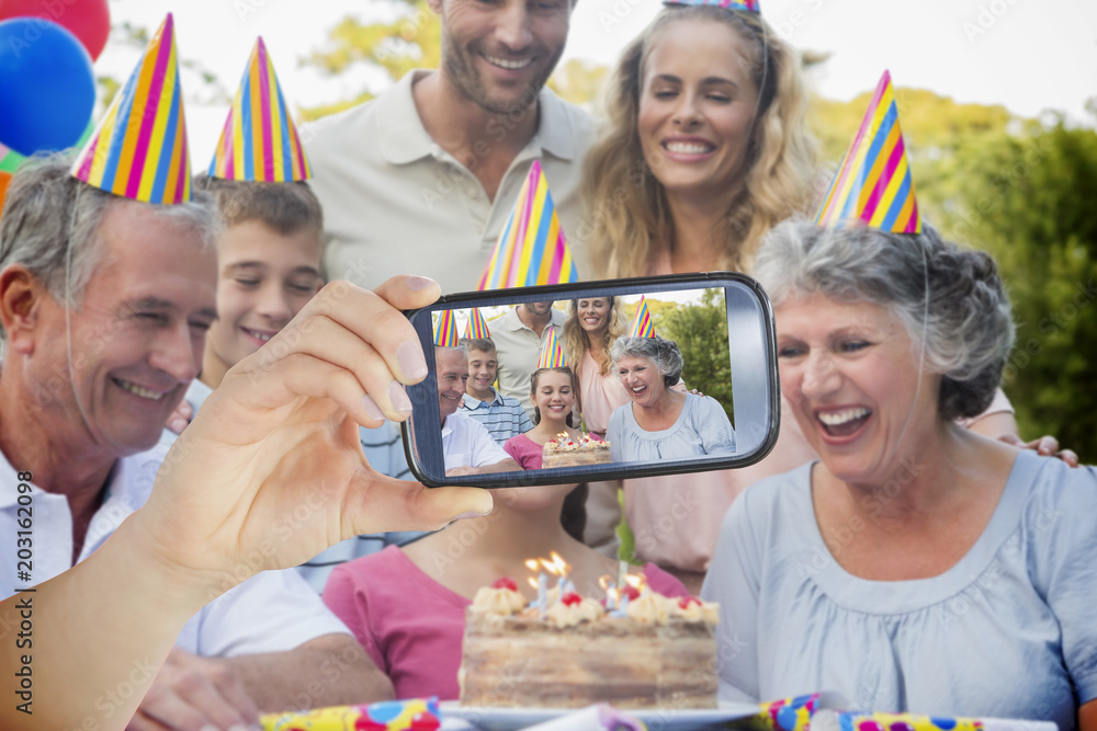 Composite image of hand holding smartphone showing photograph