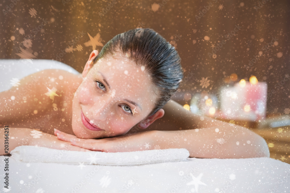 Beautiful woman lying on massage table at spa center against snow