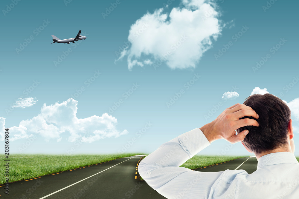 Businessman scratching his head against road leading out to the horizon