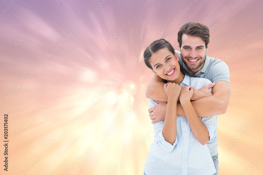 Cute couple smiling at camera against pink abstract light spot design