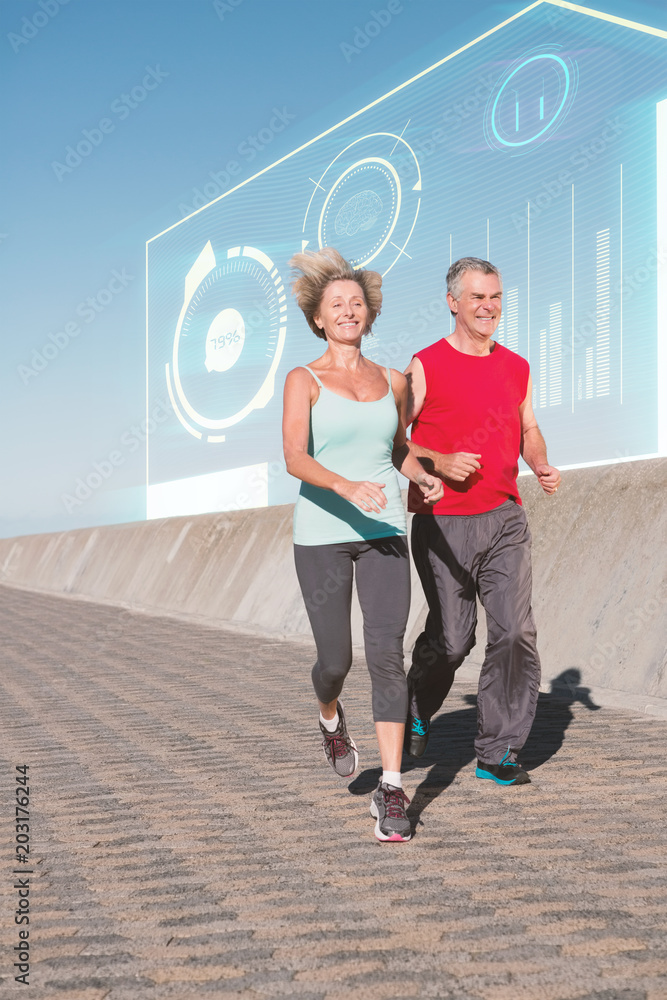 Active senior couple out for a jog against fitness interface