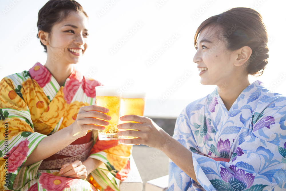 浴衣の女性たちはビールで乾杯している