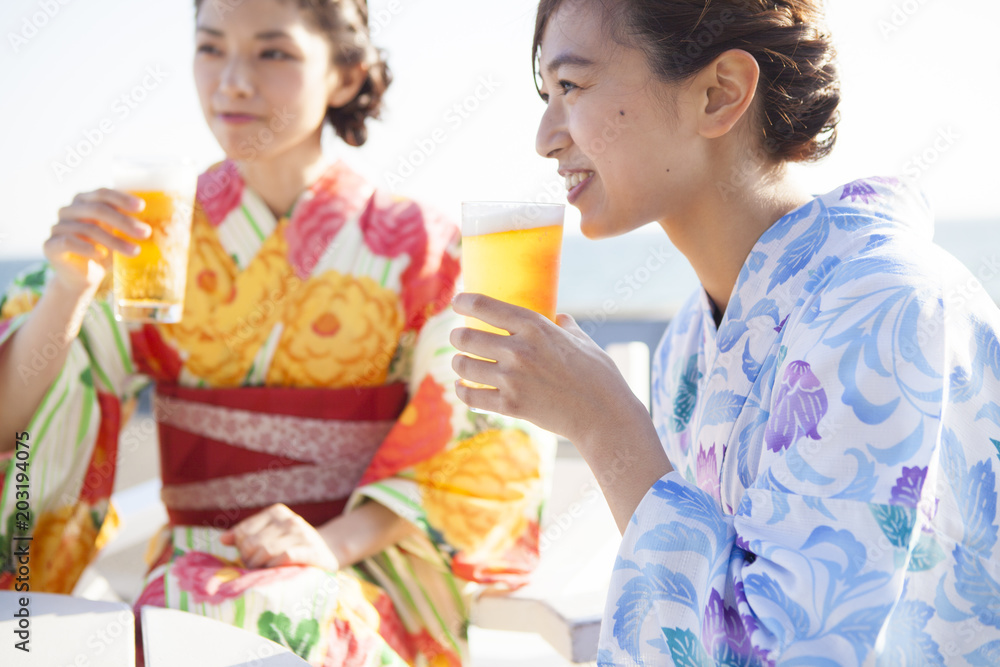 浴衣を着た女性たちは美味しそうにビールを飲んでいる