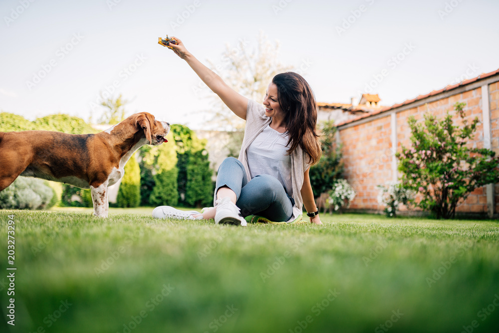 女人在户外和比格犬玩耍。