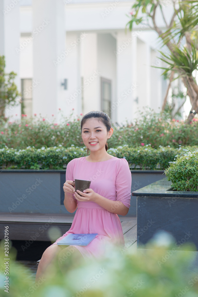 在户外咖啡馆喝咖啡的年轻女性。露天咖啡馆里快乐的女性看着凸轮的画面