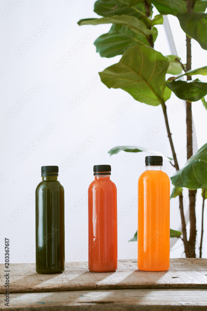 Various bottle of juice on a wooden table in the garden