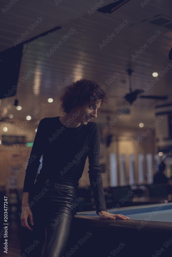 Woman playing pool at a bar