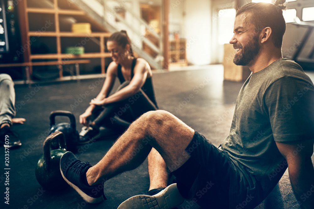 People relaxing on a gym floor after working out