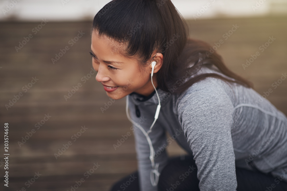 运动型亚洲女子跑步前蹲在地上