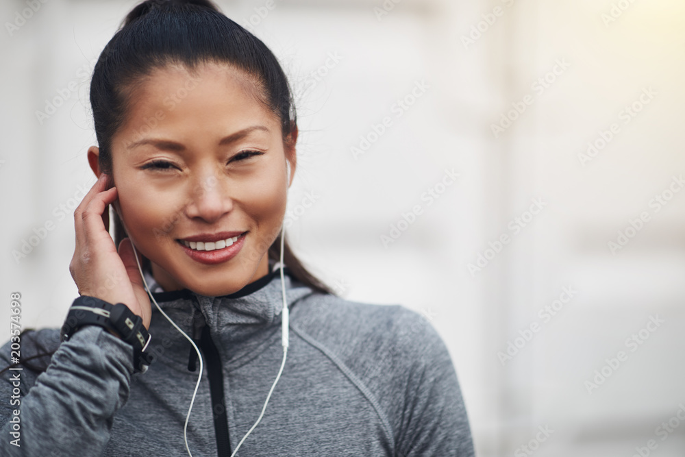 运动型年轻亚洲女性慢跑前听音乐