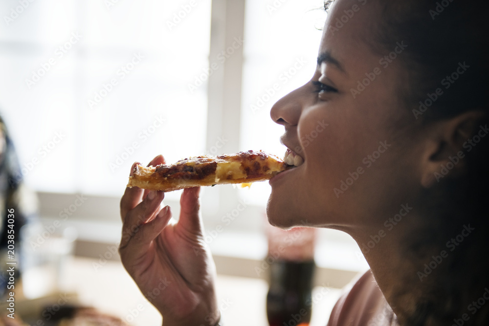 Friends eating pizza together at home