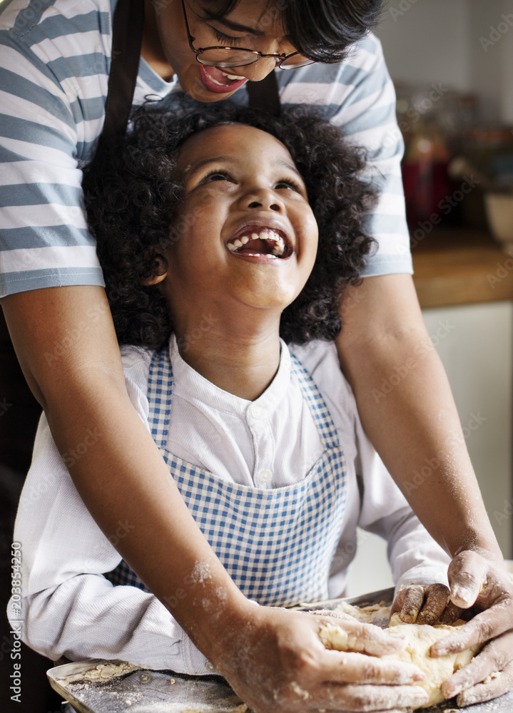 Mother and son kneading dough in the kitchen