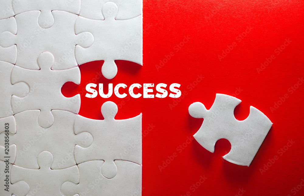 Close up piece of white jigsaw puzzle with SUCCESS text , a concept of business challenge success co