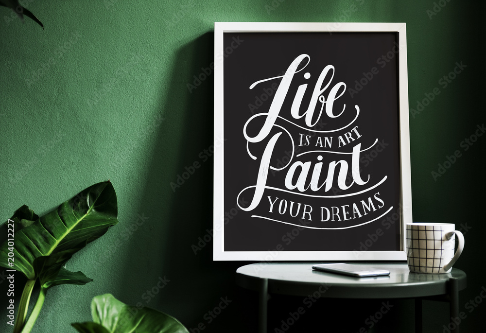 A motivation typography print on the desk against the green wall