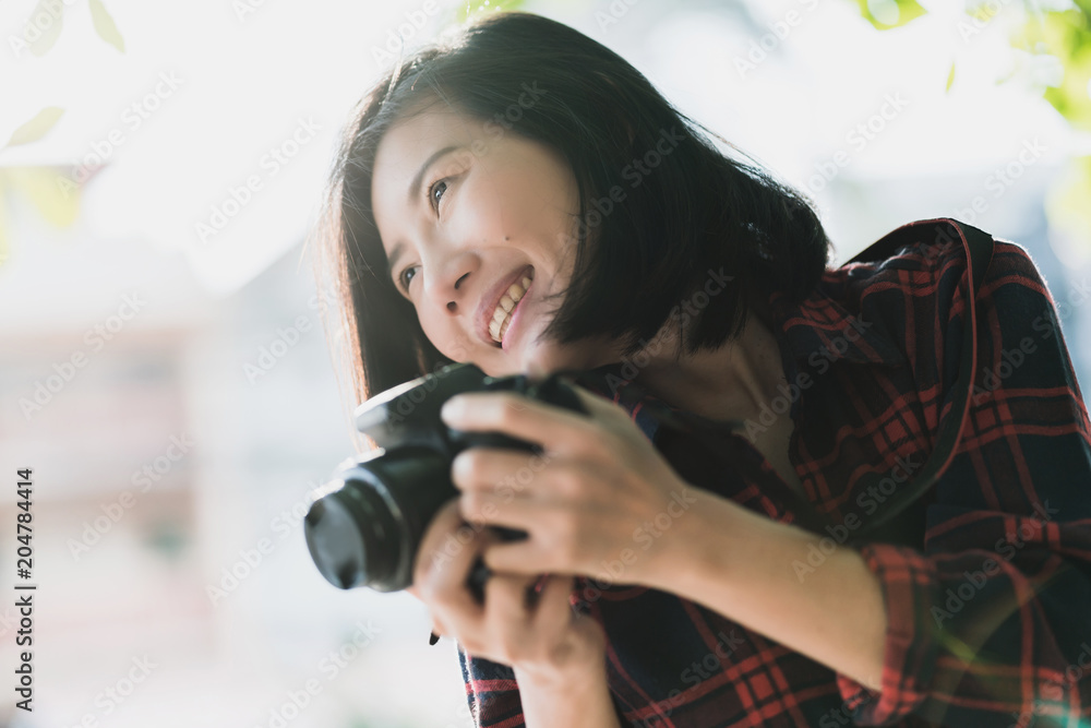 美丽的旅行者亚洲女人微笑着，在人行道上用相机度假