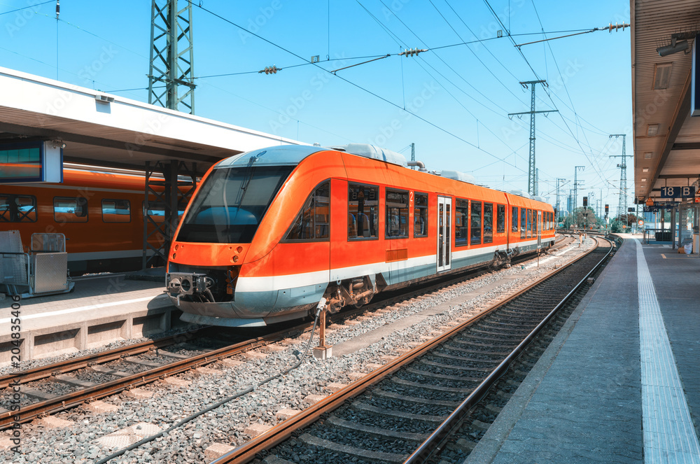 High speed red train on the railway station at sunset. Nuremberg, Germany. Modern intercity train on