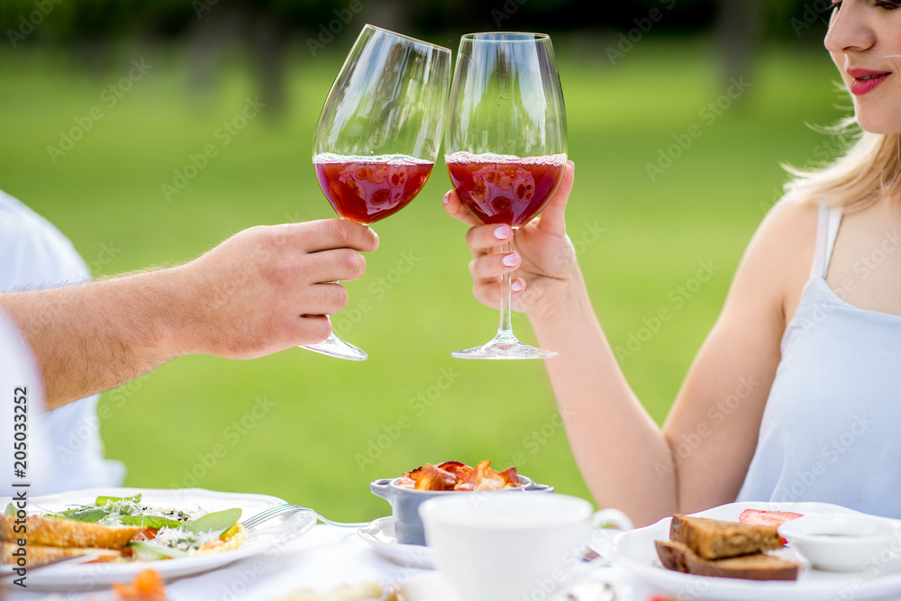 Couple clinking glasses outdoors