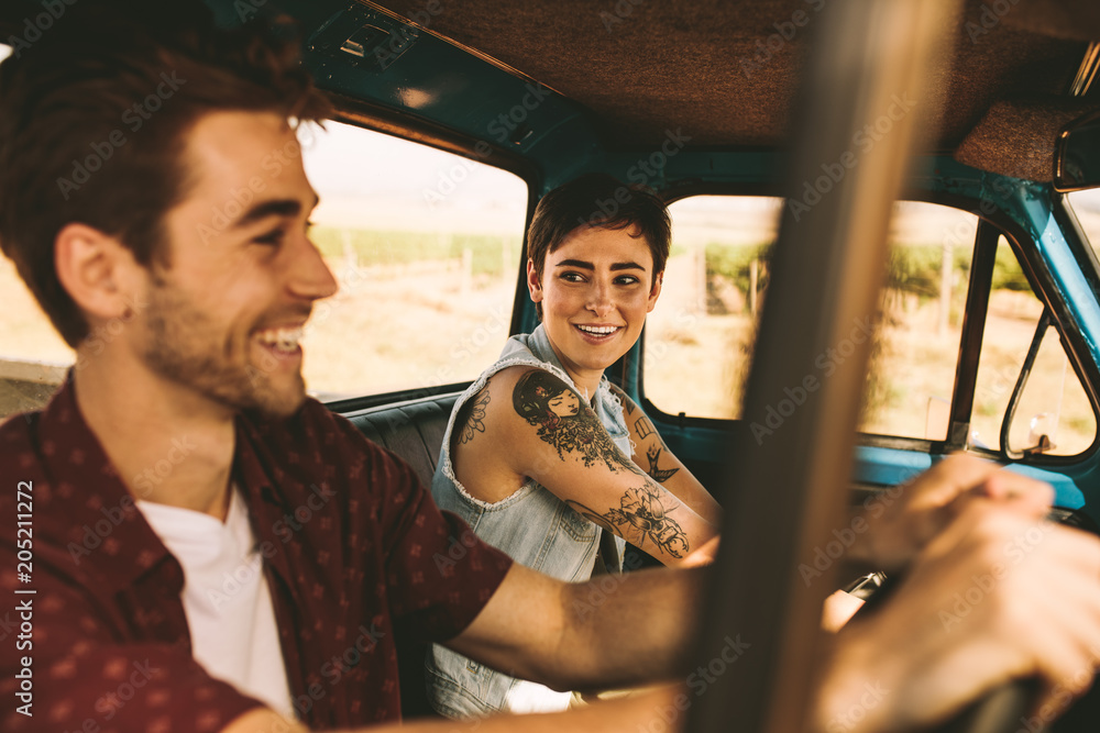 Young couple on a road trip driving in car