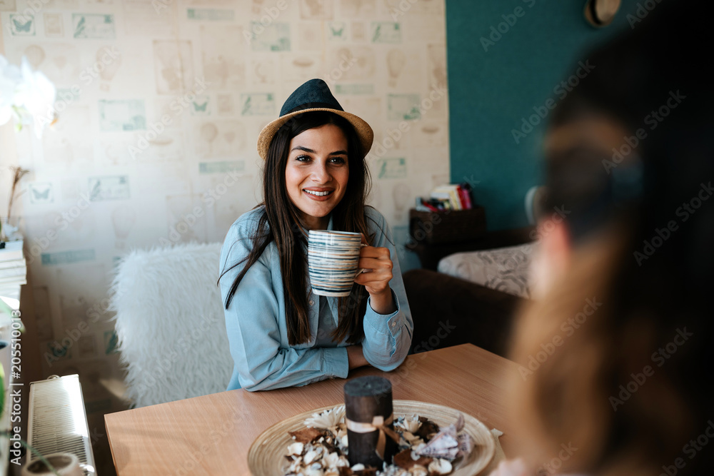 戴帽子的女人在公寓里和朋友聊天的肖像。