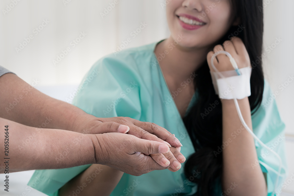 Mother hands holding her daughter patient hand sitting at the desk for encouragement, empathy, cheer