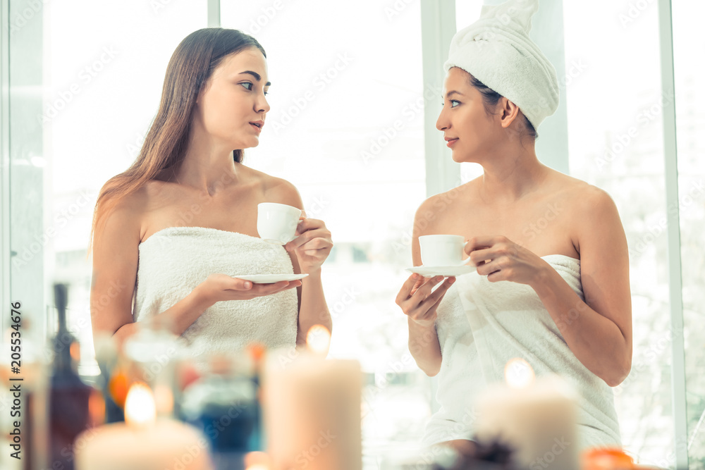 Two women drinking tea in luxury day spa.