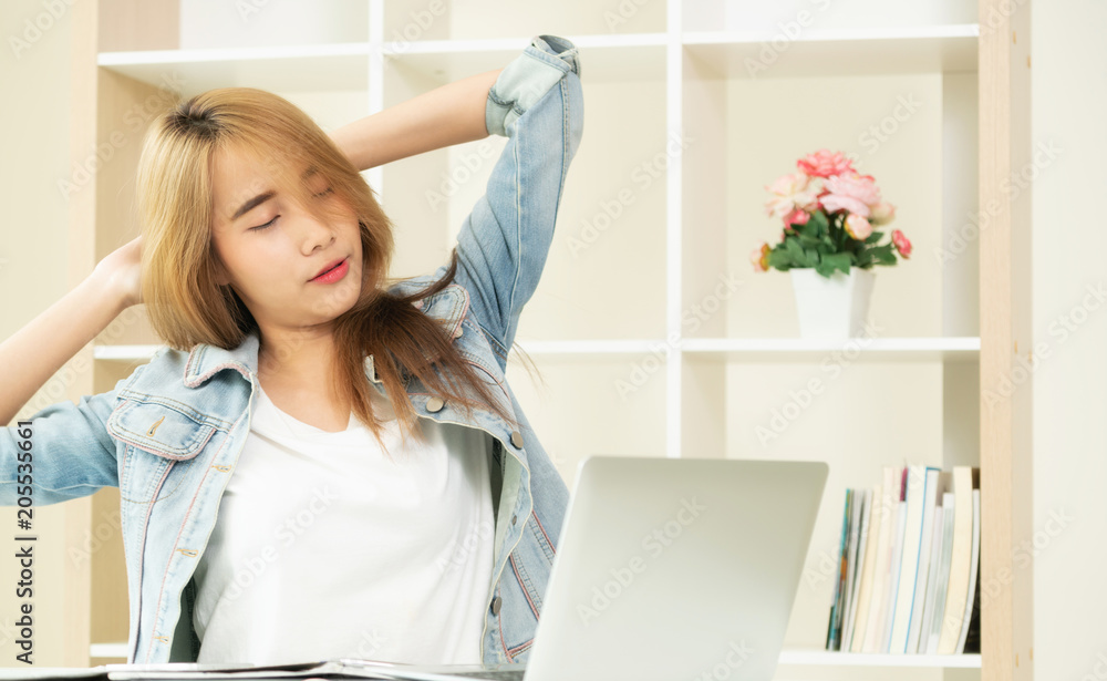 Relaxed woman stretches arms in office.