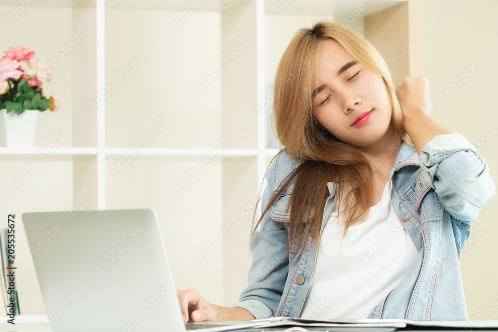 Relaxed woman stretches arms in office.