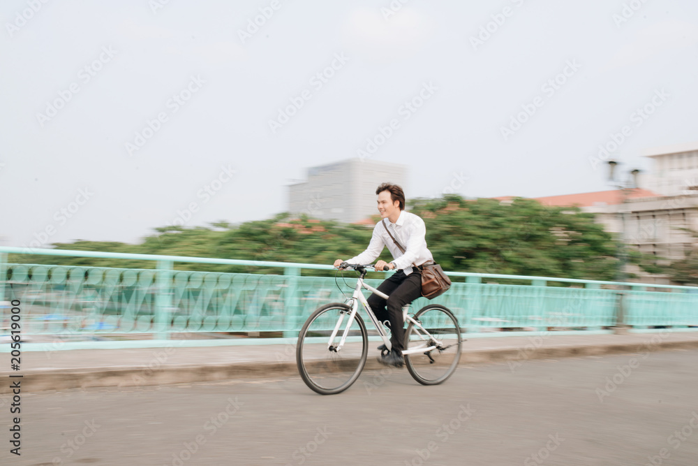 一位活跃的商人在上班路上骑自行车的侧影