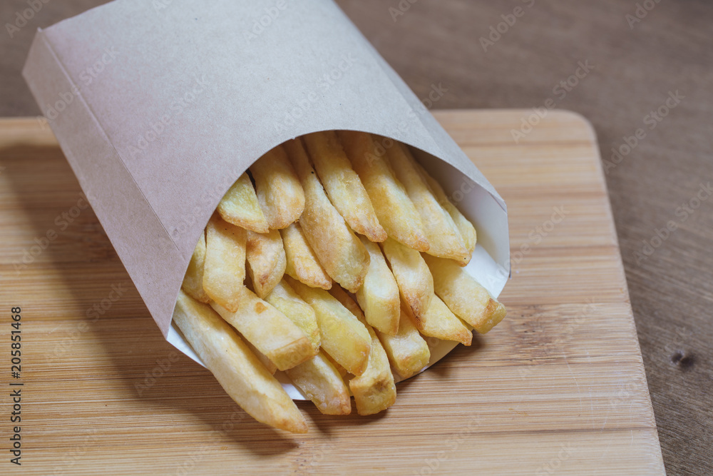 French fries on wooden background.