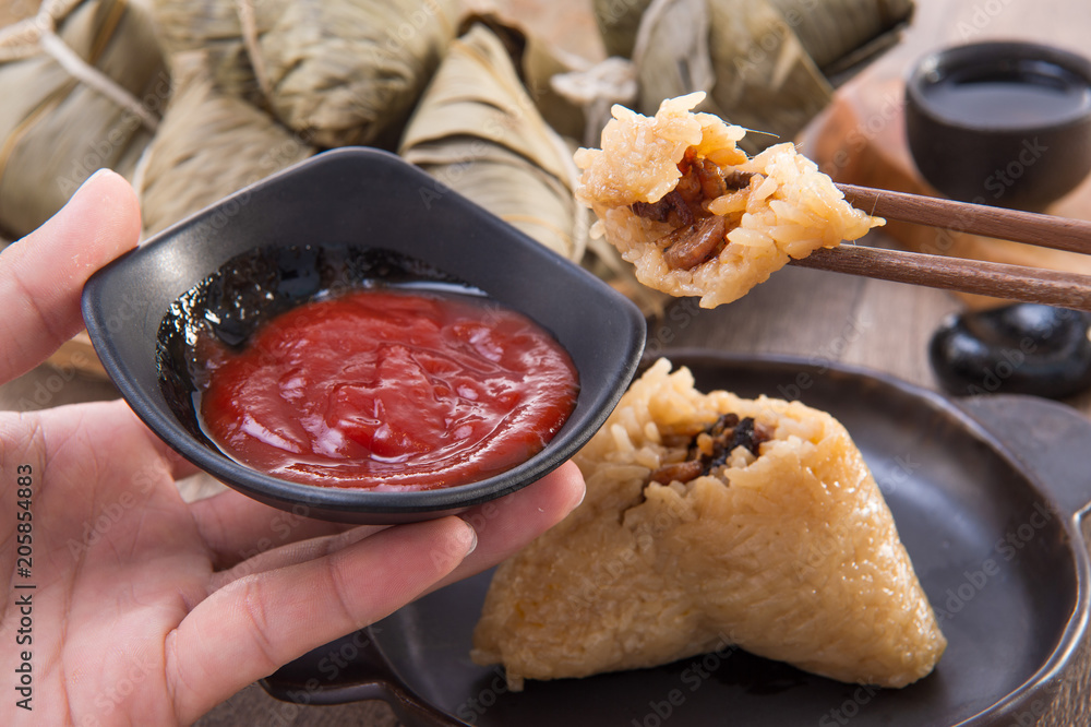 一名男子将在端午节吃粽子或粽子，这是亚洲传统食品