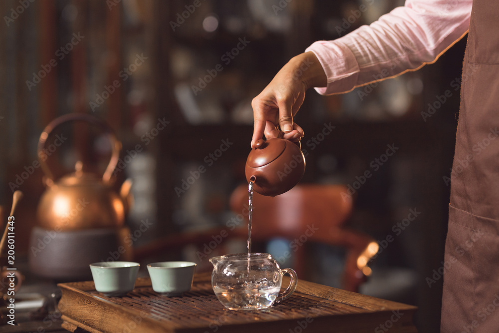 女性手在室内倒茶